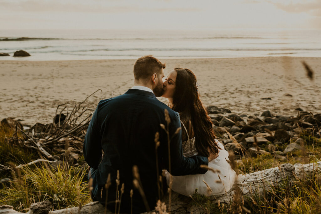 couple eloping on the oregon coast sitting on the beach